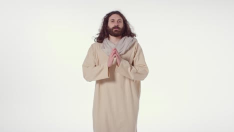 portrait of man wearing robes with long hair and beard representing figure of jesus christ praying