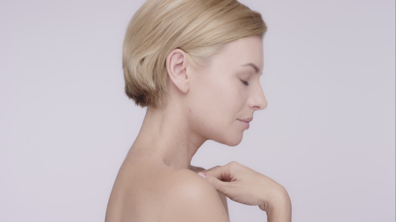 hermosa mujer sana acariciando el cuello tocando la piel en cámara lenta para la belleza concepto de cuidado de la piel en un fondo gris dragón épico rojo