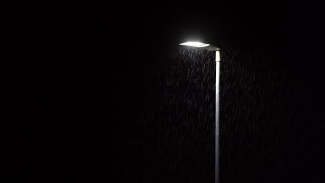 gotas de lluvia iluminadas por la lámpara de la calle durante una fuerte tormenta nocturna. 4k
