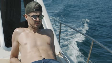 primer plano de un joven disfrutando del sol y el viento durante un viaje en barco