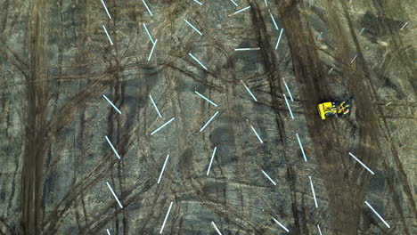 Aerial-view-of-a-worker-building-the-foundation-for-a-solar-park,-spring-day