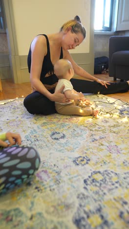 madre y bebé haciendo yoga con luces de cuerda