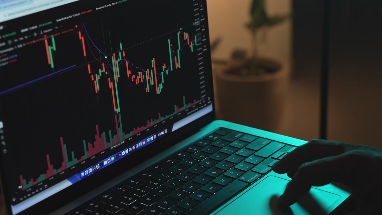 Trader che analizza grafici di borsa su un laptop tramite una piattaforma di brokeraggio