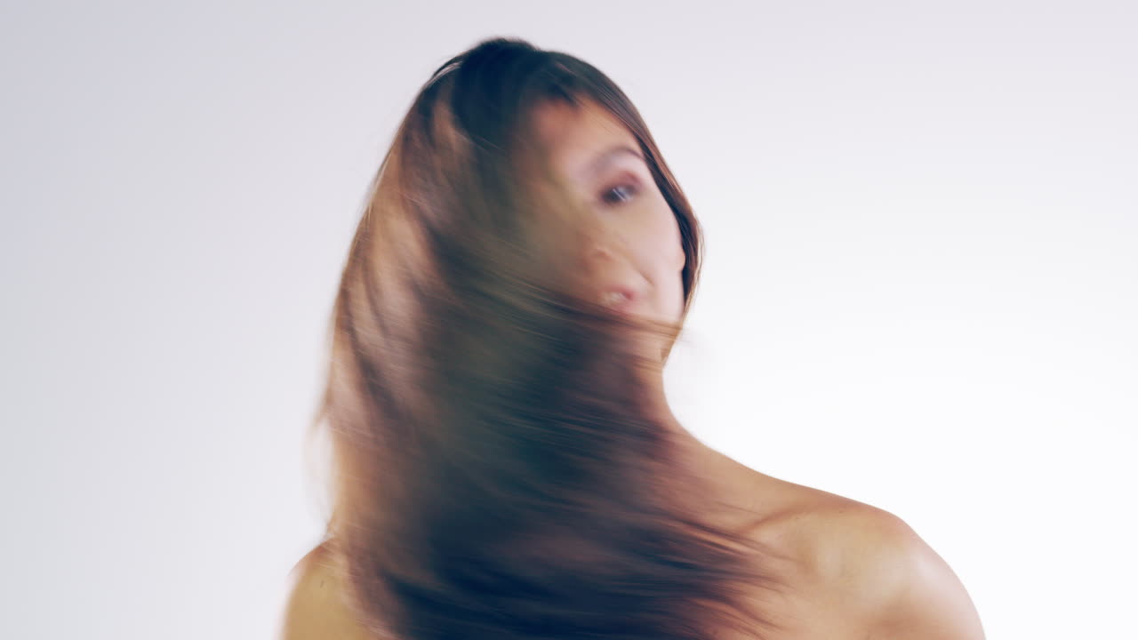 아름다운 젊은 여성이 머리카락을  ⁇ 고 있습니다.