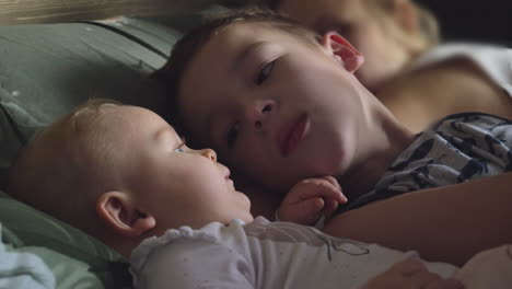 brother trying to nap with baby sister while in bed