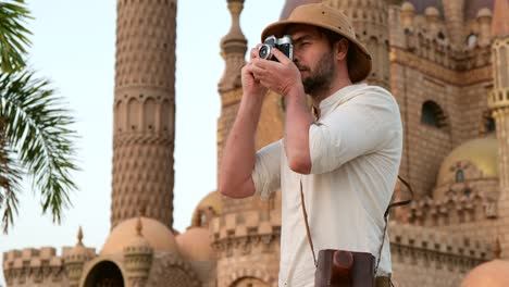 a tourist stands with a camera near the mosque,minaret.archeology