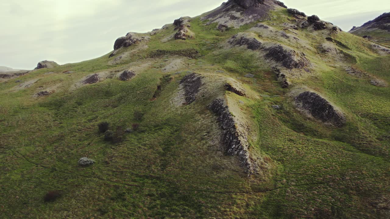 hierba aérea cumbre de la montaña verde musgo, islandia durante la cálida noche dorada puesta de sol en verano, avión no tripulado en órbita