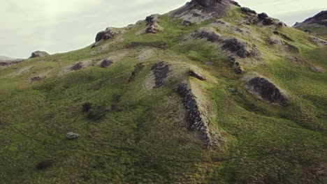 aerial grass mossy green mountain top, iceland during golden warm evening sunset in summer, orbit drone