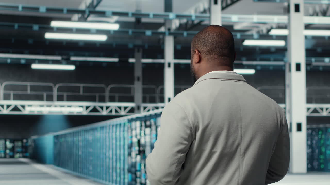 System administrator walking in data center with rows of rackmounts