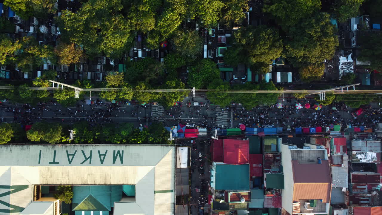 Overhead drone shot of crowded streets of Makati, sunny evening in Philippines