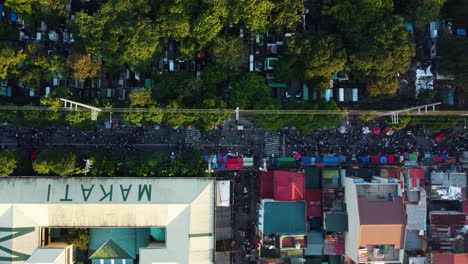 overhead drone shot of crowded streets of makati, sunny evening in philippines