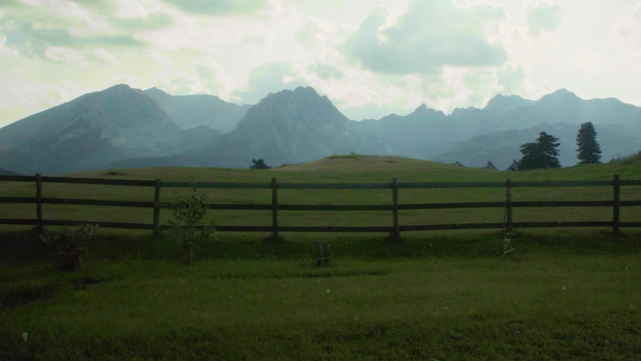 Paesaggio montano con prato verde e montagne sullo sfondo
