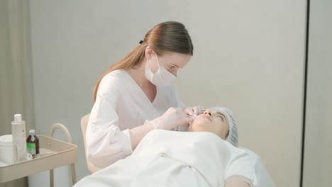 cosmetologist performing facial injection procedure