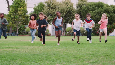 Gruppe-Aufgeregter-Kinder,-Die-Mit-Freunden-Spielen-Und-über-Das-Rasenspielfeld-Laufen