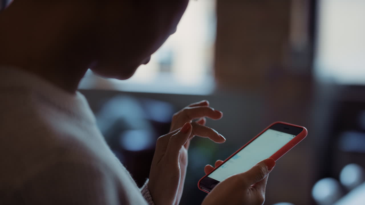 Close up of womans hands using smart phone technology to read business graphs
