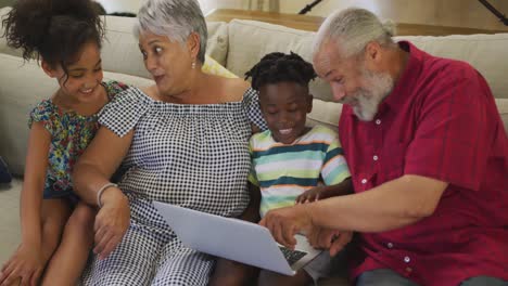 abuelos y nietos usando computadoras portátiles en casa