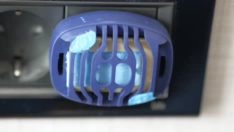 close-up of an electric insect killer plugged into a wall outlet