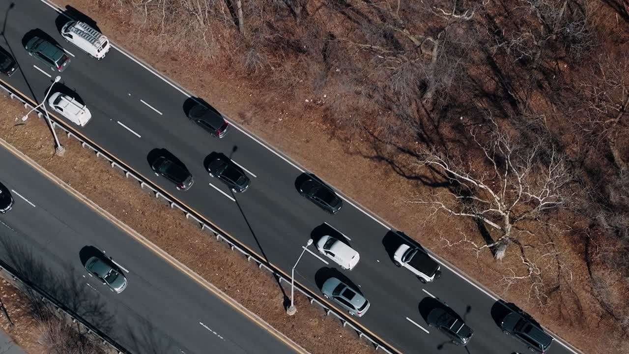 Trafikbillede af en vej ved siden af nøgne træer i New York om vinteren