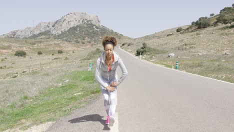 Young-woman-stretching-among-mountains