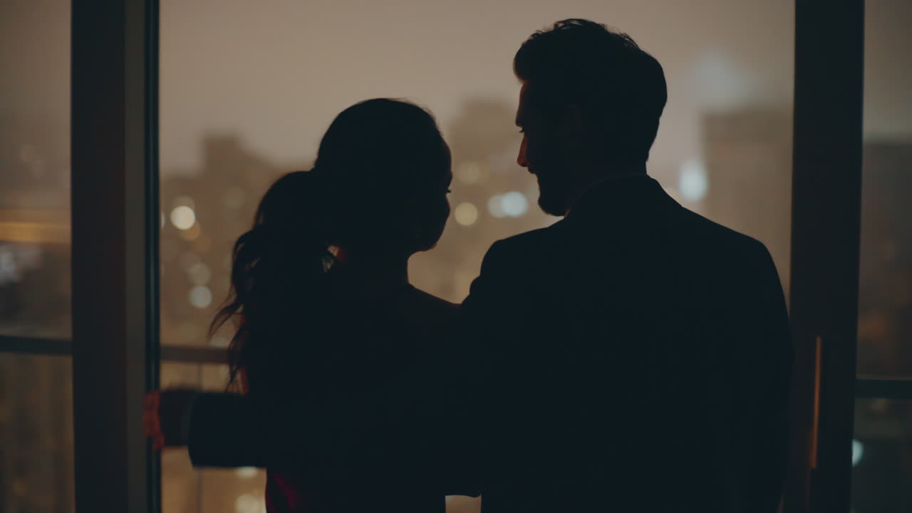 저녁 창문에서 포옹하는 로맨틱 한  실루 도시 풍경 호텔 뒷면