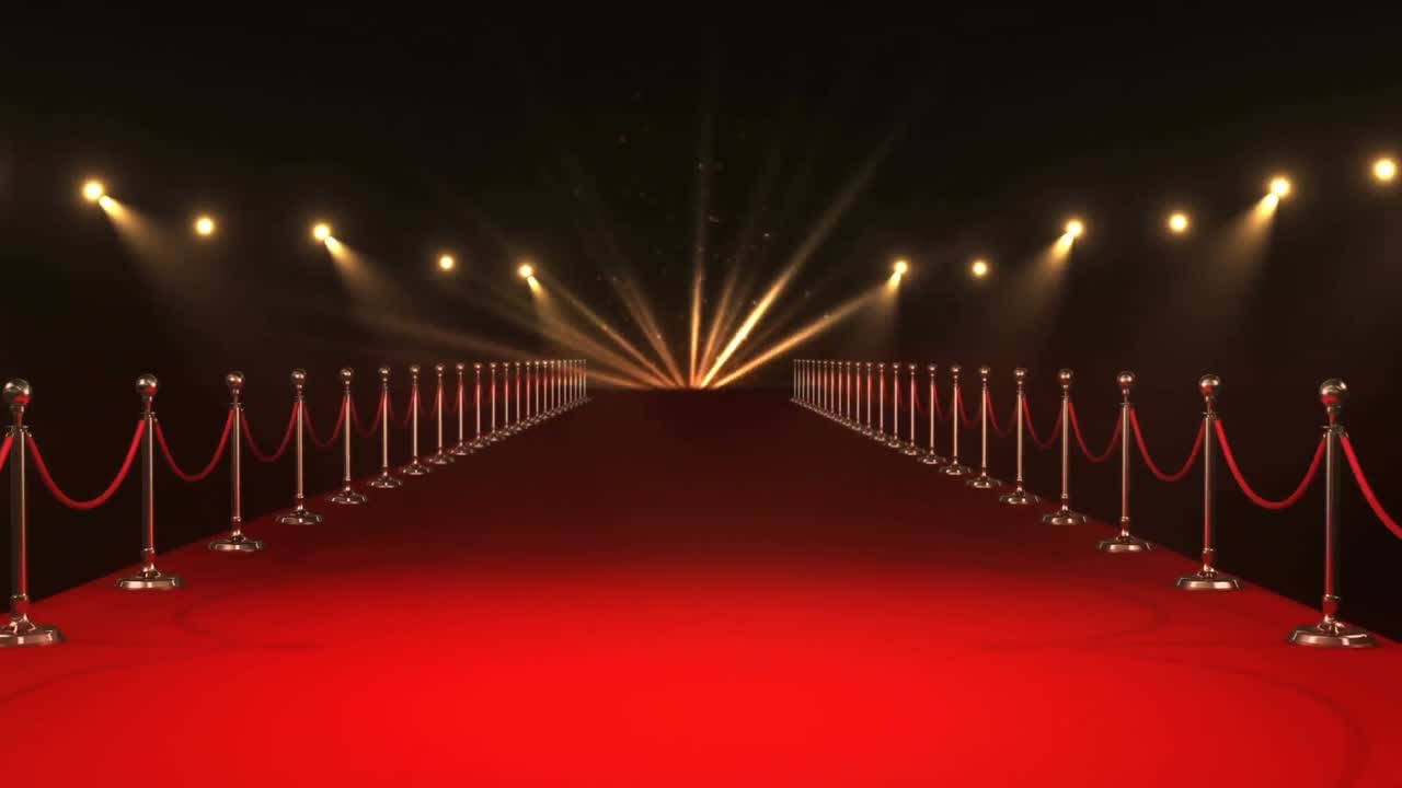 Animazione di forme caleidoscopiche oro e rosse su una location con tappeto rosso con faretti mobili