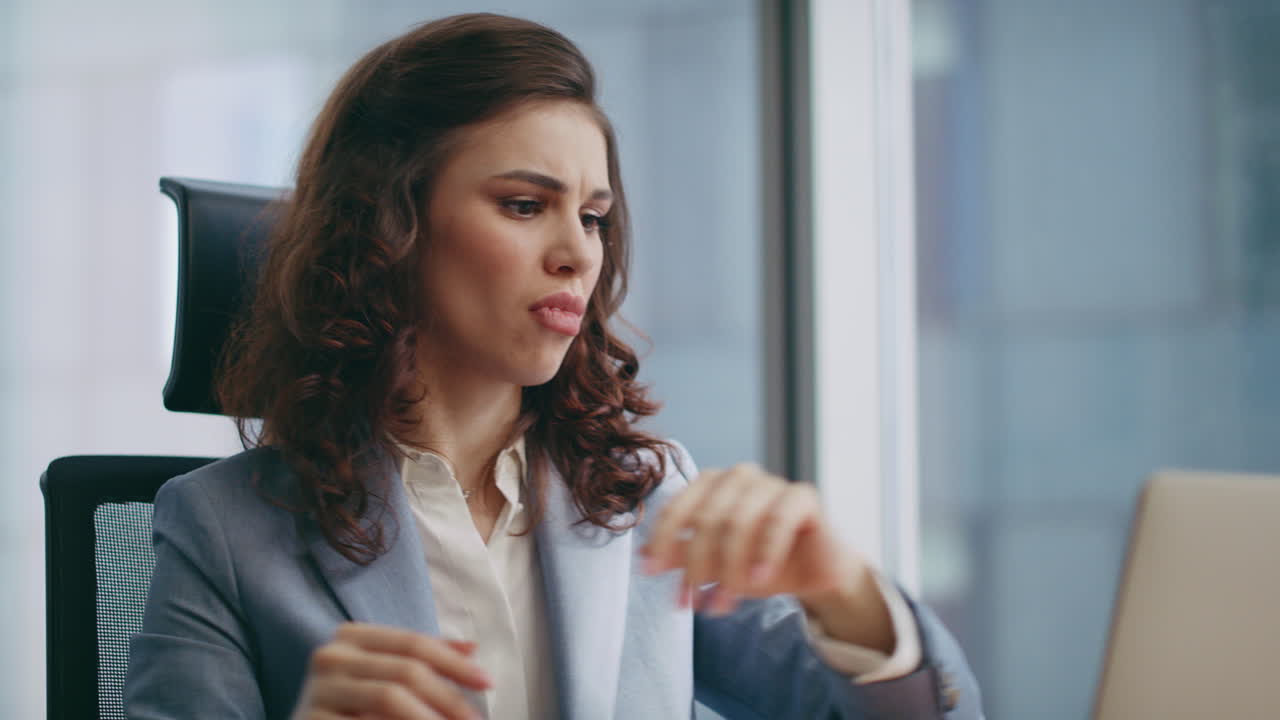 Empresária furiosa gritando em conversa no smartphone sentada no escritório em close-up.