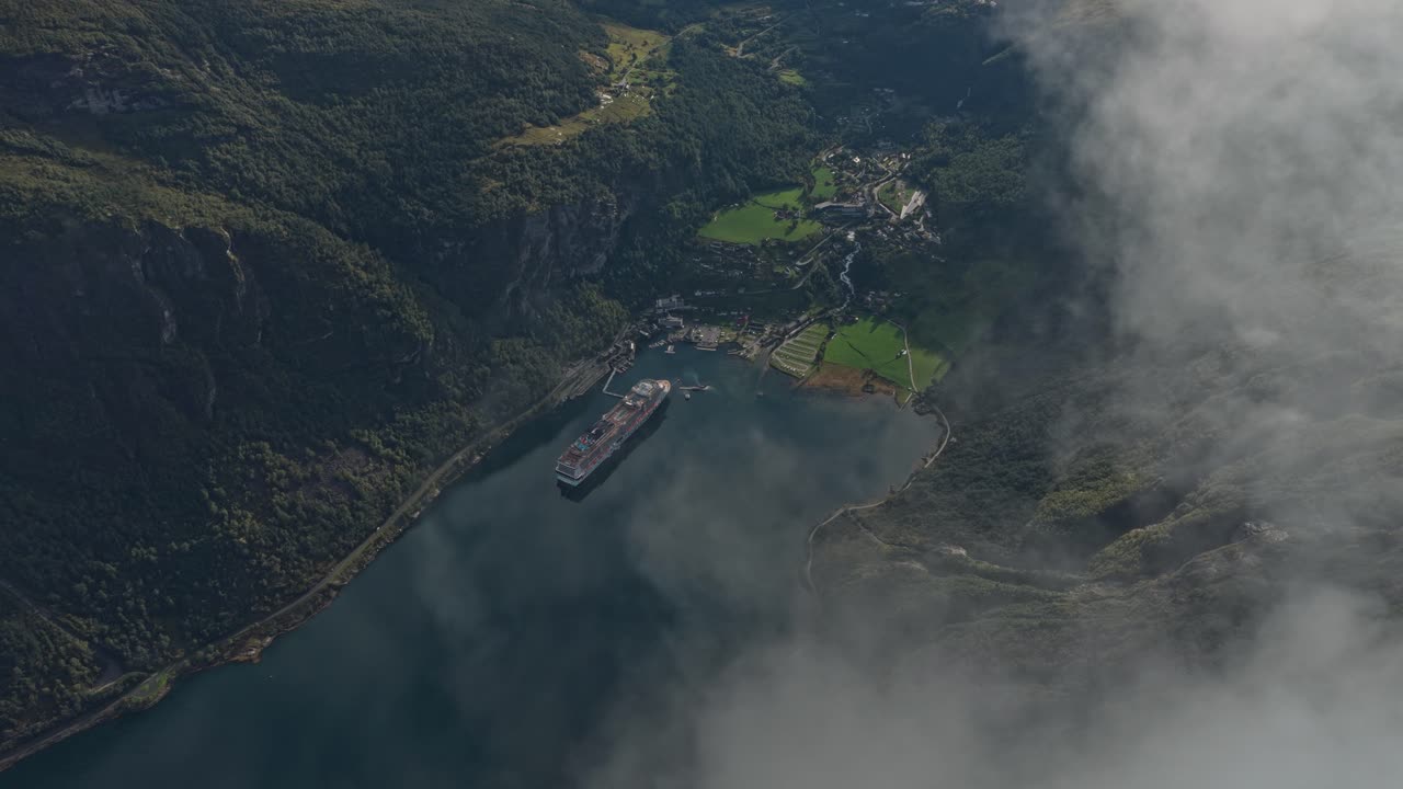Dronebillede over landsbyen Geiranger og skib under et blødt skydække, Norge.