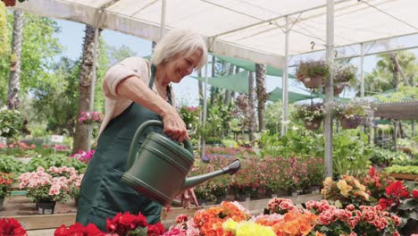 a woman tending to flowers in a greenhouse