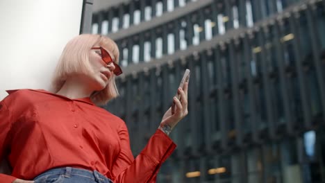 stylish young woman using phone in city