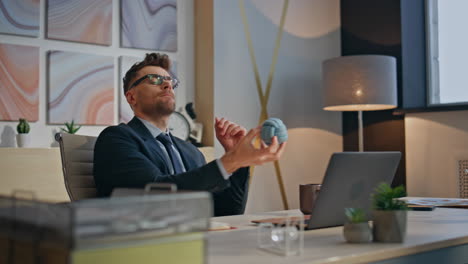 inspired businessman thinking ideas tossing ball in creative office closeup
