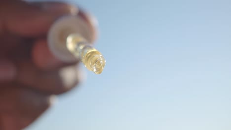 hand holding a dropper bottle with liquid