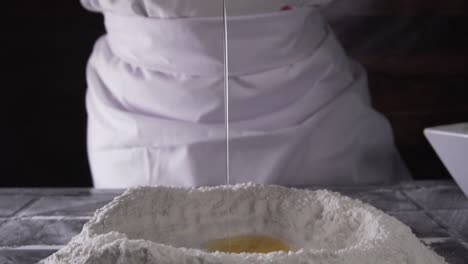 chef pouring an egg onto flour in slow motion