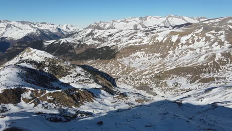 Vista-Panorámica-Volando-Sobre-La-Cresta-De-La-Montaña-Con-Rocas-Nevadas