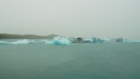 static view over lake jokulsarlon with beautiful blue icebergs on a cloudy day