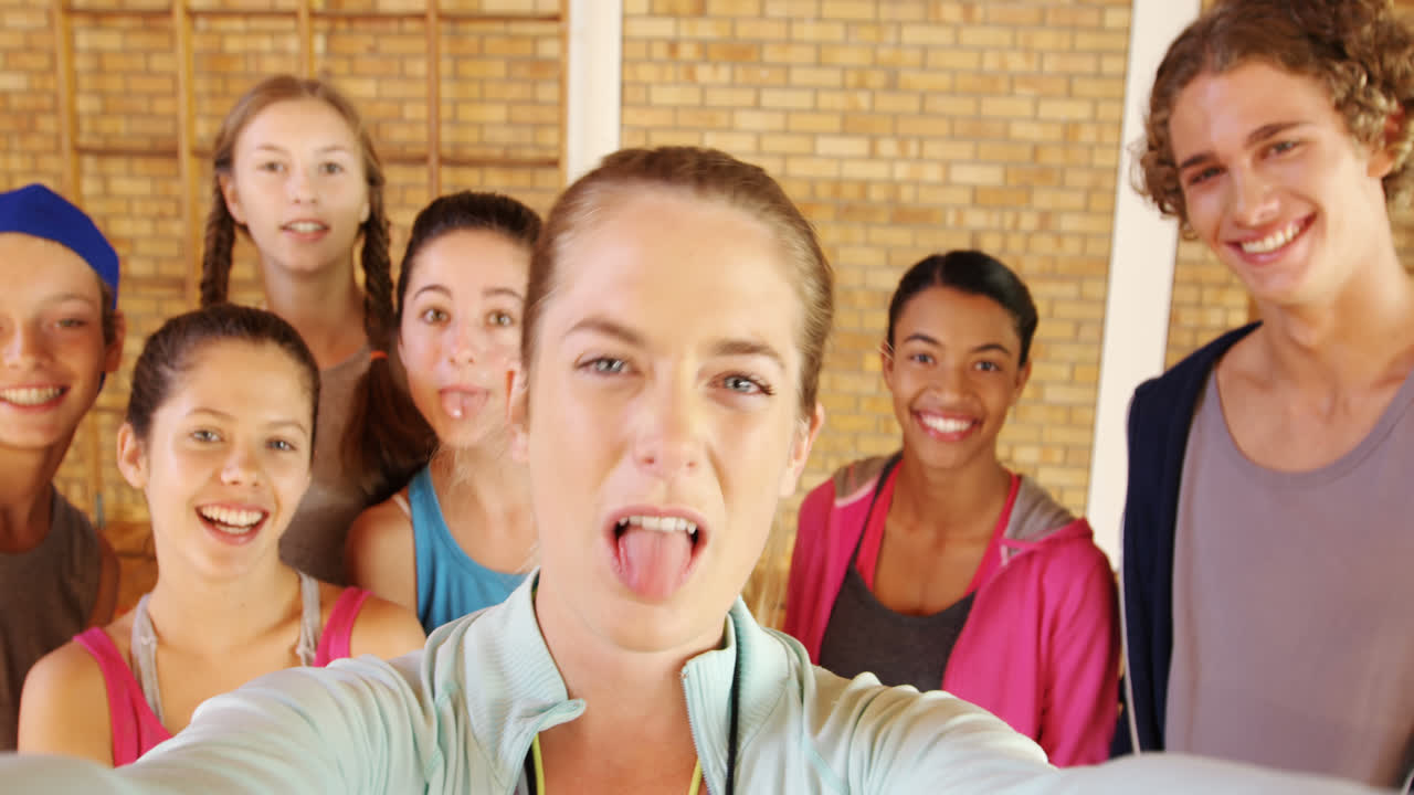 여자 코치 와 고등학교 아이 들 이 셀카 를 찍고 있다