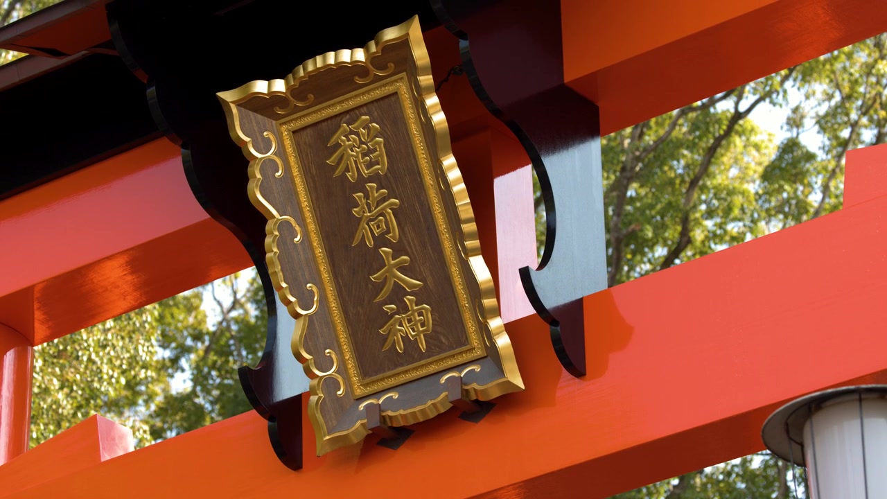 Lavvinkelbillede af en vermilionfarvet helligdomsport med et træskilt med kanji-kalligrafi.