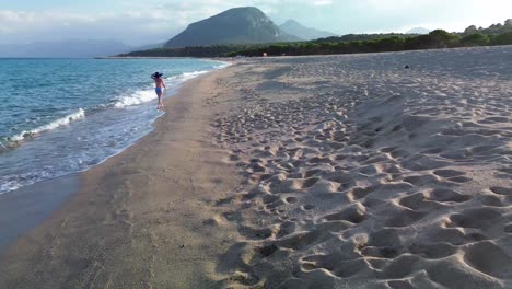 es una mujer caminando por la playa.