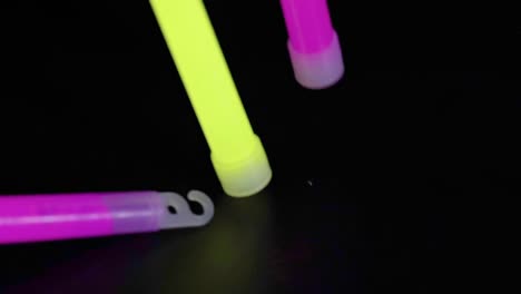 colorful glow sticks arranged on a dark background, showcasing vibrant neon hues and captivating illumination.