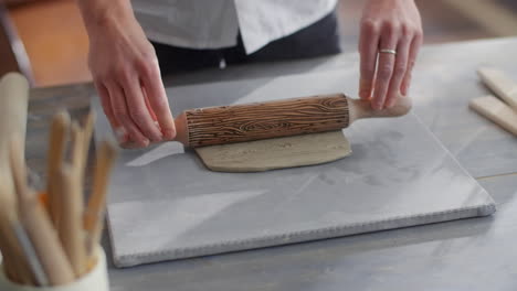 woman working with clay using rolling pin