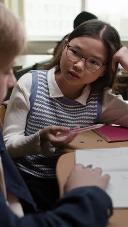 two students studying and interacting in a classroom setting