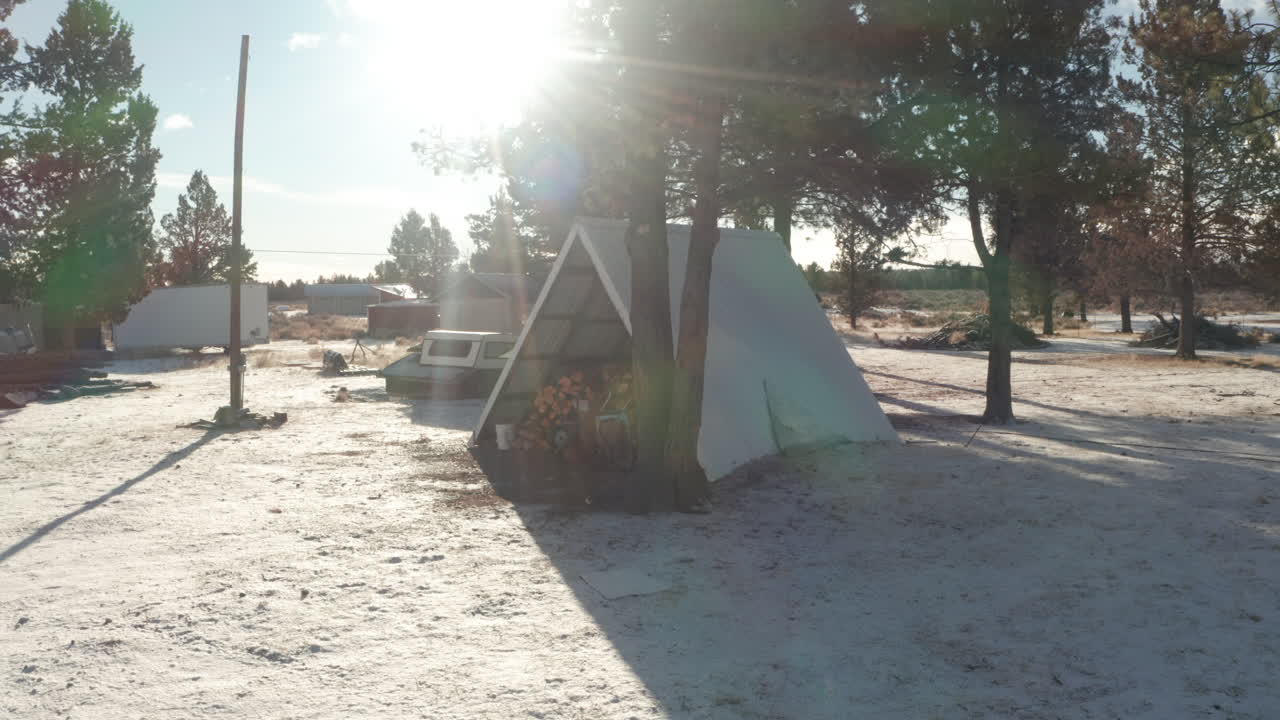 겨울에 나무를 저장하는 데 사용되는 프레임 오두막 주위를 돌고 있습니다.