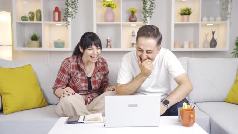 Couple-watching-comedy-movie-on-laptop.-They-are-having-fun.