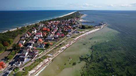 Aerial-backwards-shot-of-Baltic-Sea-with-Hel-Island-and-Kuznica-village-during-sunny-day,-Poland---top-down-coral-reef-and-sandy-beach