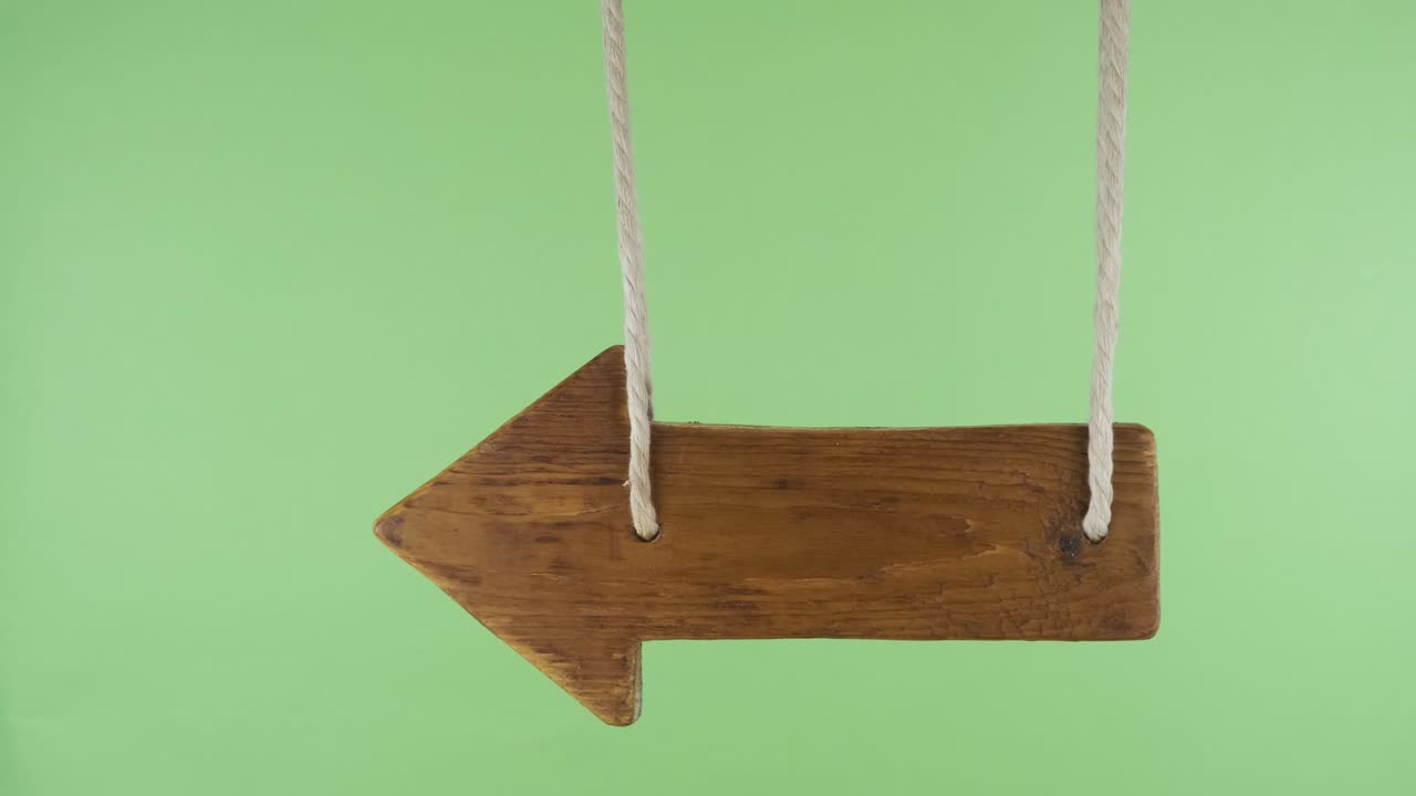 Wooden pointer sways in the wind. Isolated on a green screen.