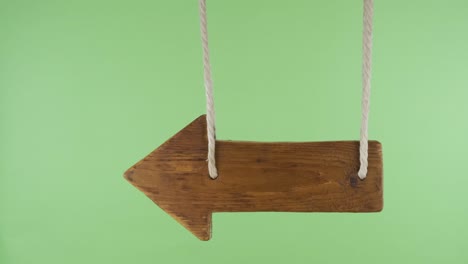 wooden pointer sways in the wind. isolated on a green screen.