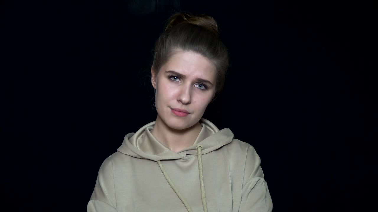 Young woman in beige hoodie, studio portrait