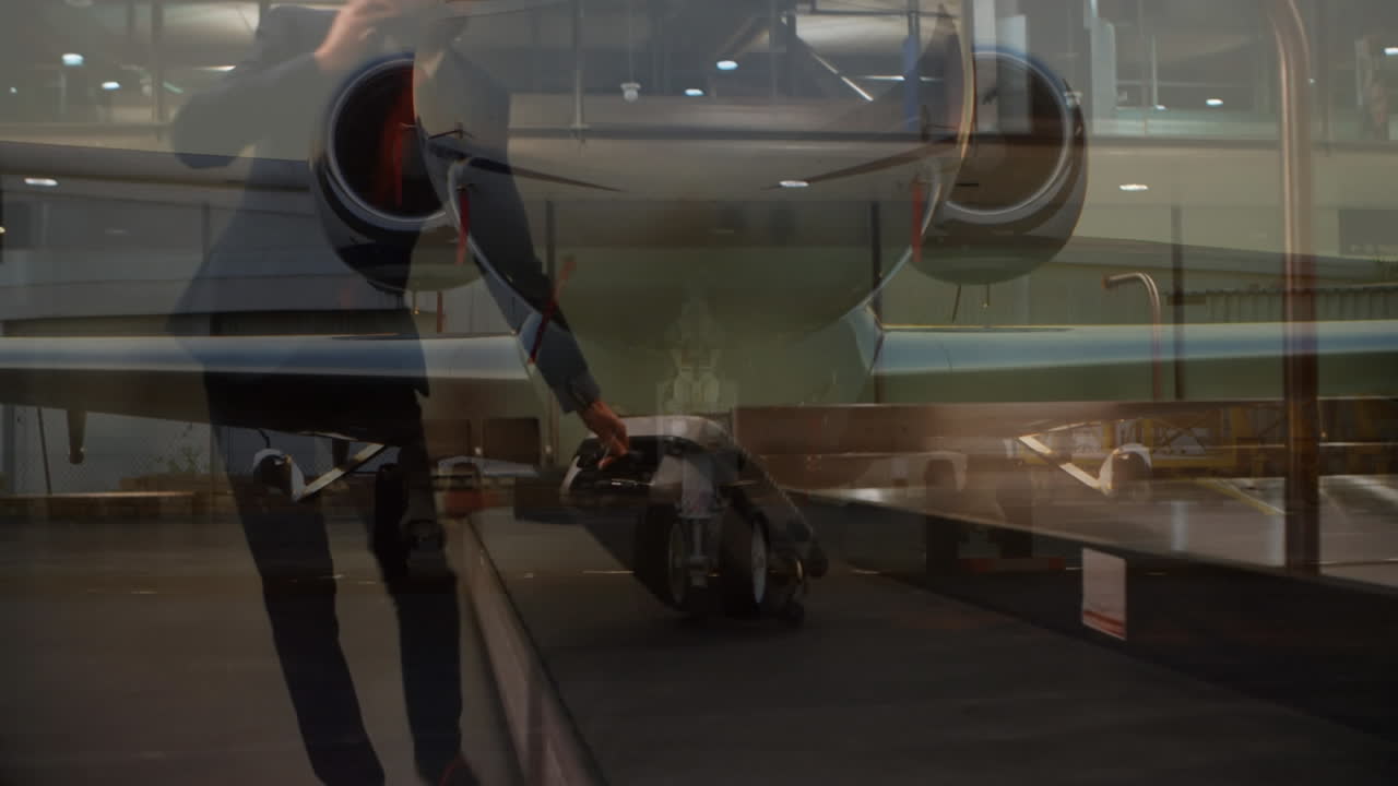 공항 에서 컨베이어 벨트 에서 가방 을 집어 들인 사업가 를 상대로 하는 비행기