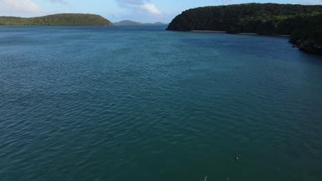 Vista-Aérea-Por-La-Mañana-Sobre-Un-Embarcadero-De-Una-Isla-Remota-Y-Un-Barco-Amarrado-En-La-Zona-Tropical-De-Australia