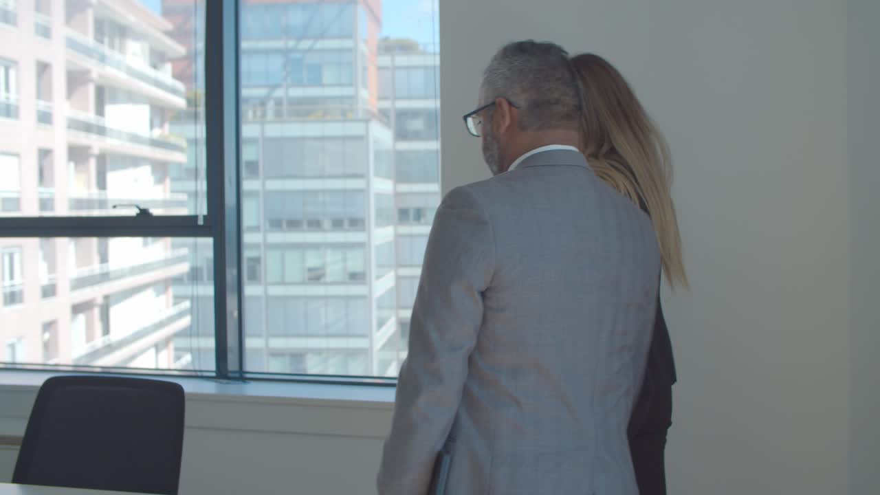 dos socios de negocios hablando mientras caminan hacia la mesa de reuniones