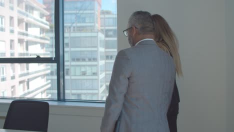 two business partners talking while walking to meeting table